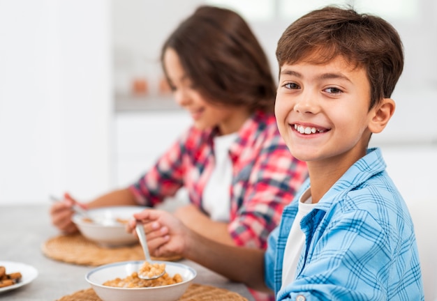 Fratelli di smiley di vista laterale che mangiano prima colazione