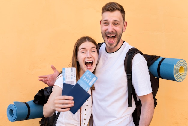 Side view of smiley tourist couple with plane tickets and passports