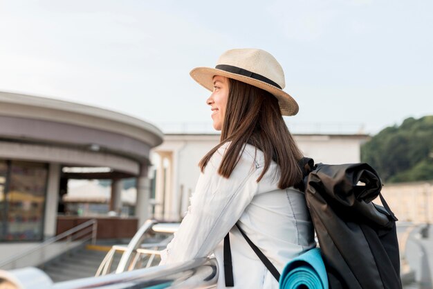 旅行中に景色を眺めながら笑顔の女性の側面図