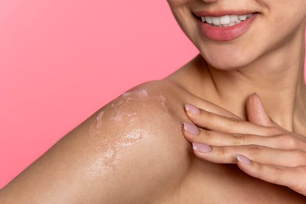 Side view smiley woman applying body cream