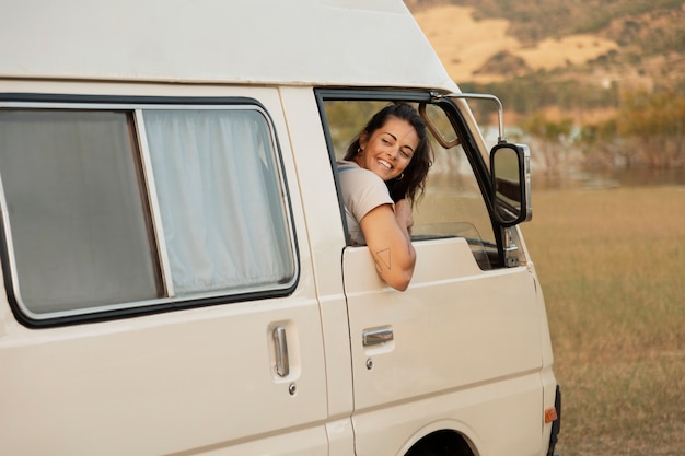 Side view smiley woman in campervan