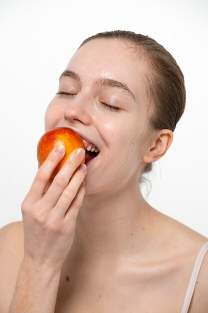 Side view smiley woman eating fruit