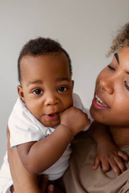 Foto gratuita bambino della holding della donna di smiley di vista laterale