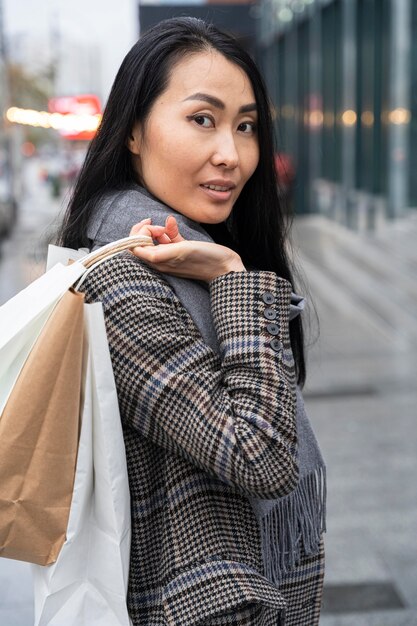 Side view smiley woman holding bags