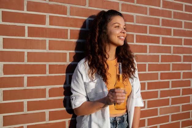 Foto gratuita bottiglia della holding della donna di smiley di vista laterale