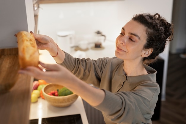 Free photo side view smiley woman holding bread