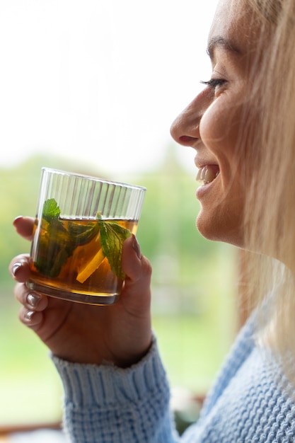 Side view smiley woman holding drink