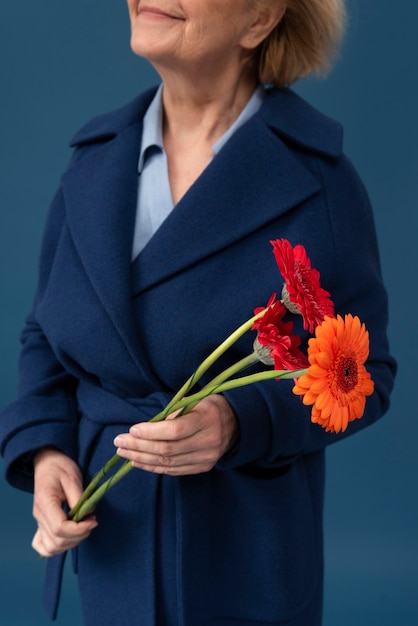 Side view smiley woman holding flowers