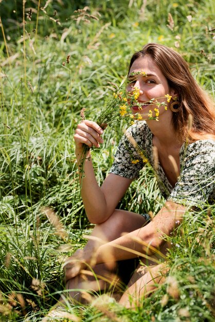 Side view smiley woman holding flowers