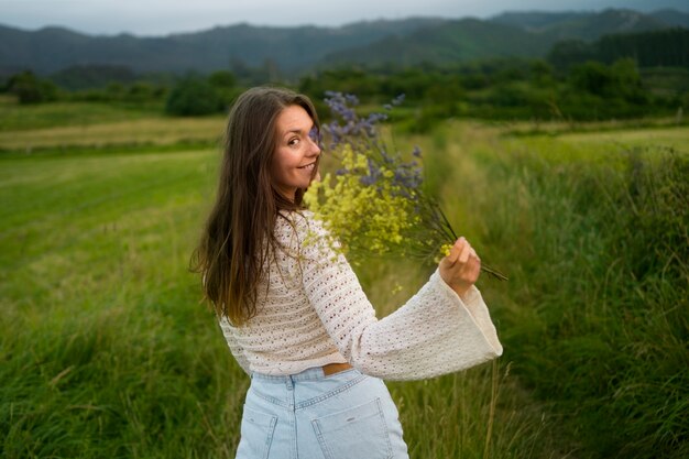 Side view smiley woman holding flowers