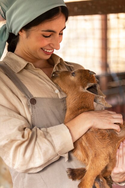 Side view smiley woman holding goat