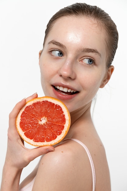 Side view smiley woman holding grapefruit