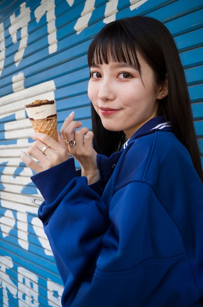 Foto gratuita cono gelato della holding della donna di smiley di vista laterale