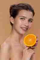 Free photo side view smiley woman holding orange