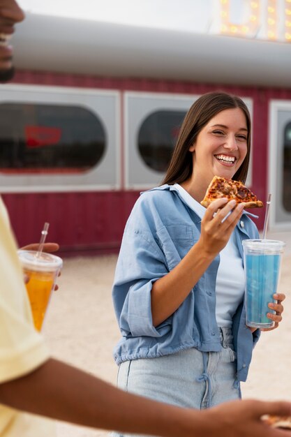 Side view smiley woman holding pizza