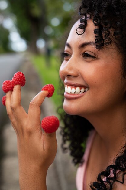 Side view smiley woman holding raspberries