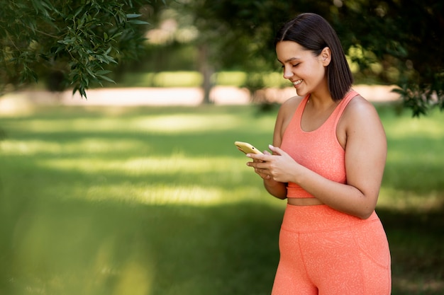 Side view smiley woman holding smartphone