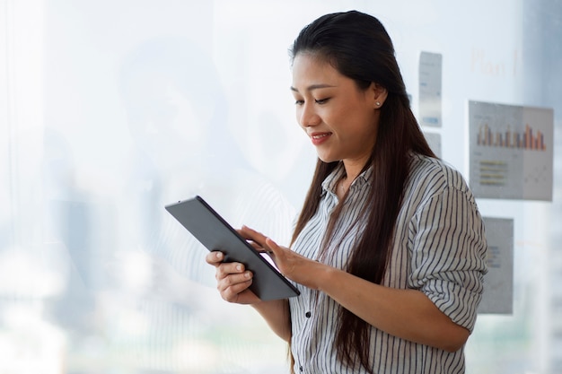 Free photo side view smiley woman holding tablet