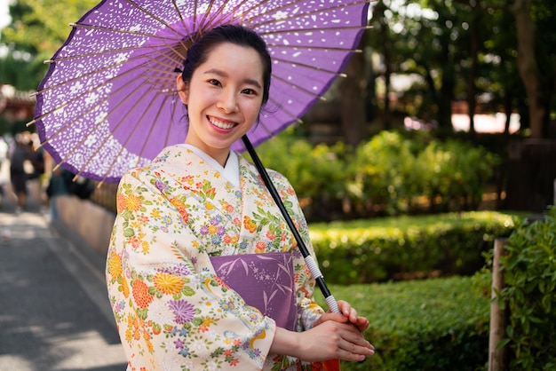 Side view smiley woman holding wagasa umbrella