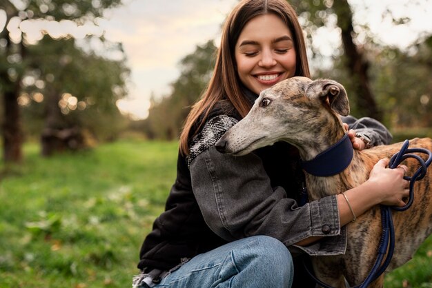 犬を抱きしめる側面図スマイリー女性