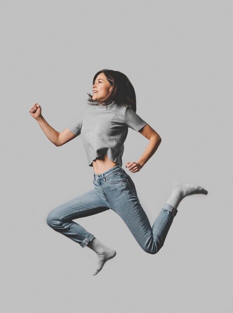 Side view of smiley woman jumping in the air