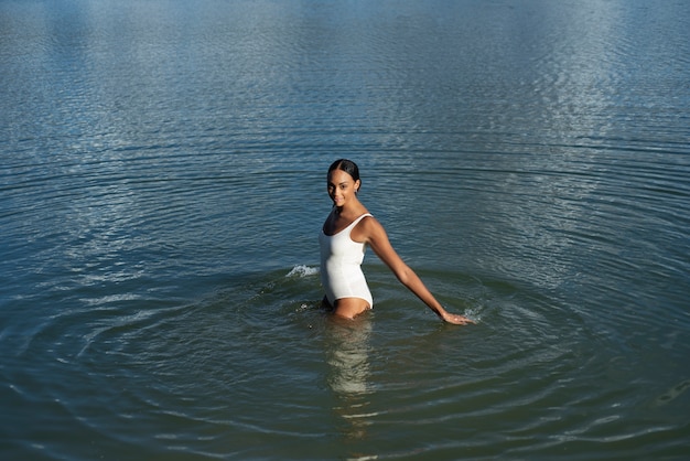 Free photo side view smiley woman in lake