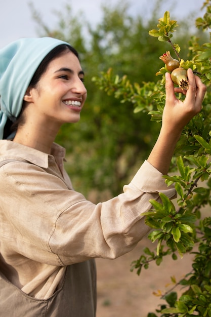 Side view smiley woman looking at fruit