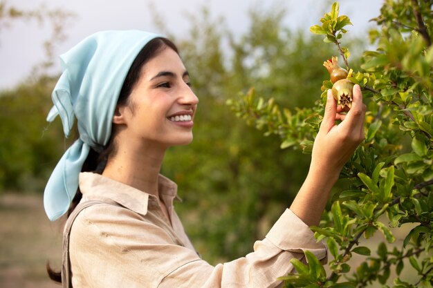 Side view smiley woman looking at fruit