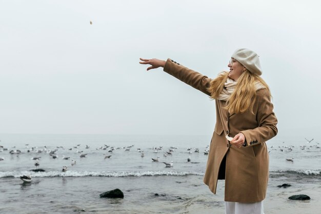 Side view of smiley woman outdoors at the beach in winter