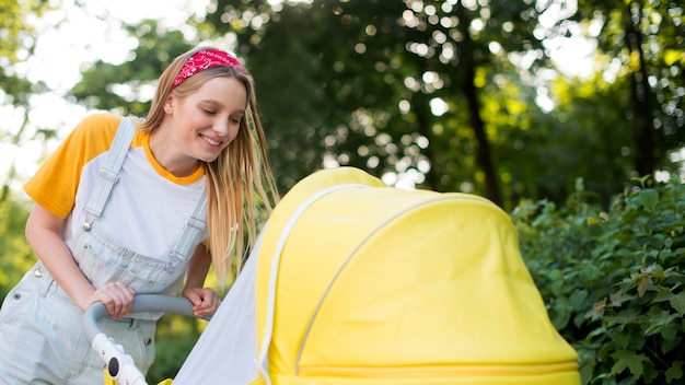 Side view of smiley woman outdoors with stroller