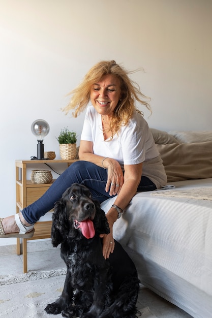 Foto gratuita donna sorridente di vista laterale che accarezza il cane