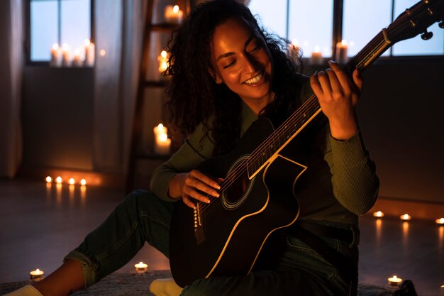 side view smiley woman playing the guitar