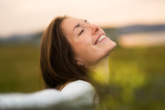 Side view smiley woman posing outside