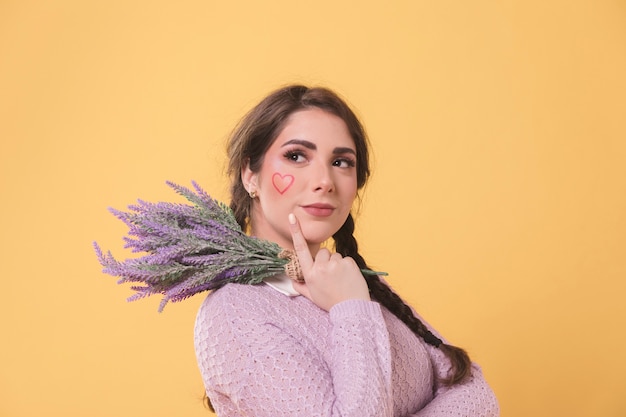 Side view of smiley woman posing while holding lavender