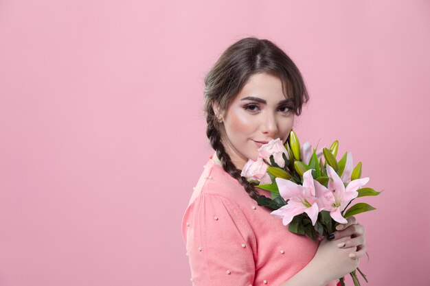 Side view of smiley woman posing with bouquet of lilies and copy space