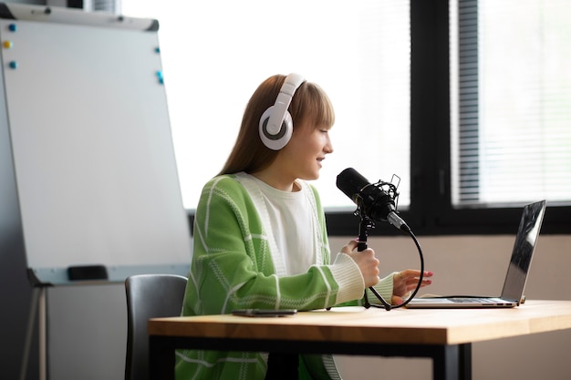 side view smiley woman recording podcast