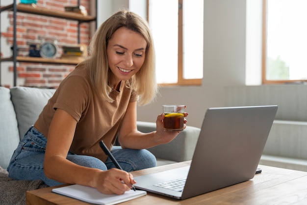 Free photo side view smiley woman taking notes