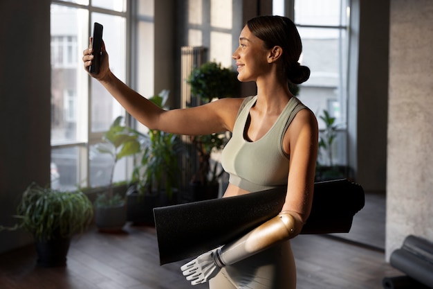 Foto gratuita donna sorridente di vista laterale che prende selfie