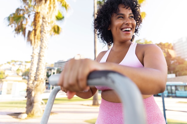 Foto gratuita donna sorridente di vista laterale che si allena all'esterno