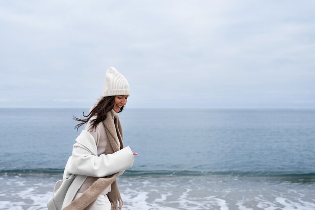 Side view smiley woman walking on beach