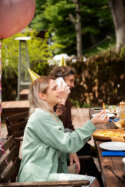 Side view smiley woman wearing party hat