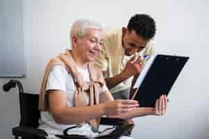 Free photo side view smiley woman in wheelchair