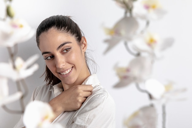 Side view of smiley woman with defocused orchids