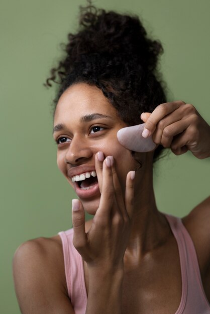 Side view smiley woman with gua sha