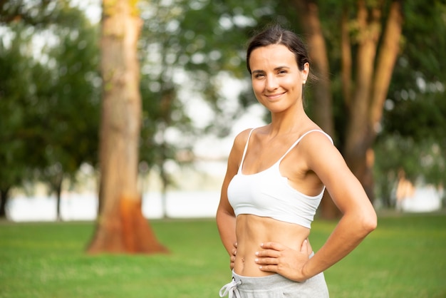 Side view smiley woman with hands on hips