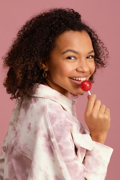 Side view of smiley woman with lollipop