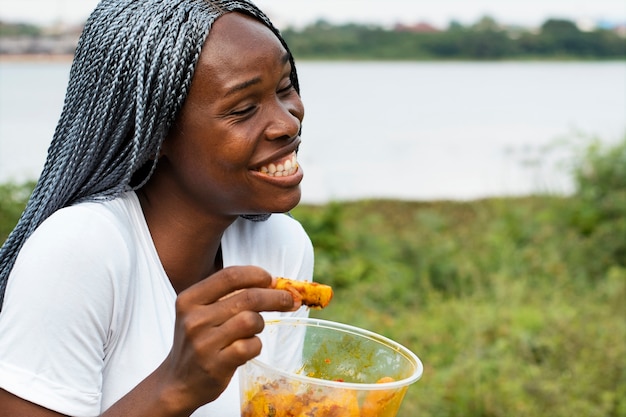 Donna sorridente di vista laterale con il pranzo