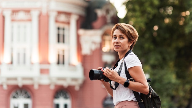 Foto gratuita donna di smiley vista laterale con macchina fotografica