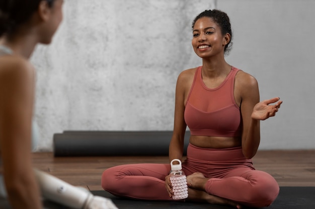 Free photo side view smiley women doing yoga