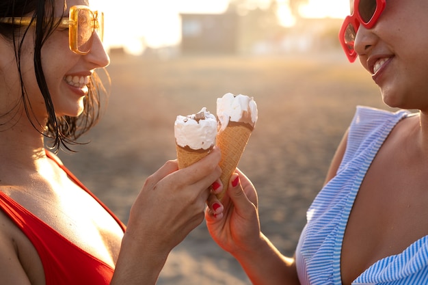 Foto gratuita donne di smiley di vista laterale che mangiano il gelato